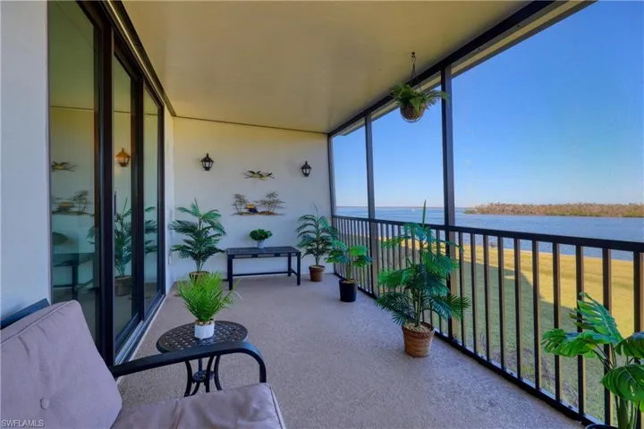 Sunroom / solarium with a wall of windows, a water view, and carpet