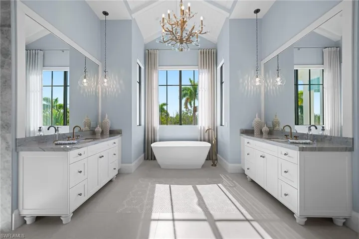 Full bathroom with wooden ceiling, a chandelier, two vanities, a freestanding bath, and healthy amount of natural light
