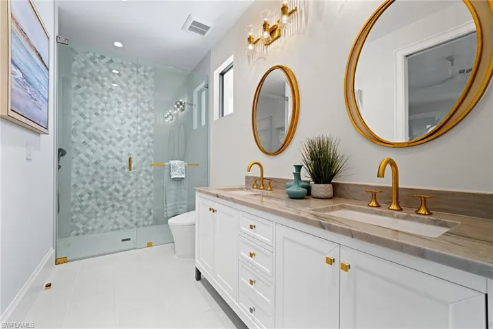 Full bath featuring light tile patterned floors, double vanity, a stall shower, and recessed lighting