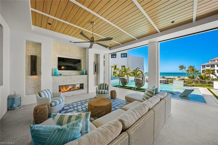 View of patio / terrace with ceiling fan, an outdoor living space with a fireplace, and an outdoor pool