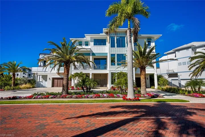 View of front of property with decorative driveway, stucco siding, and a balcony