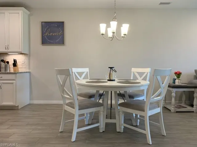 Dining room with a notable chandelier and light hardwood / wood-style floors