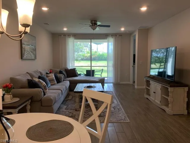 Living room with dark hardwood / wood-style floors and ceiling fan