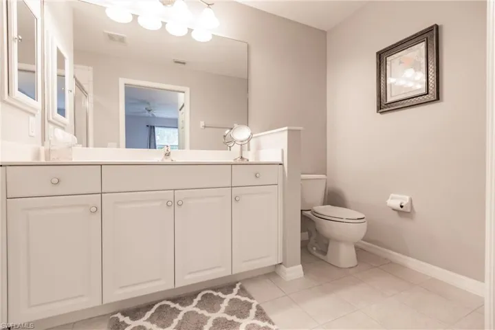 Bathroom with ceiling fan, vanity, toilet, and tile floors