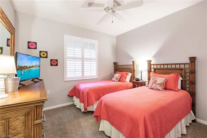 Carpeted bedroom featuring ceiling fan