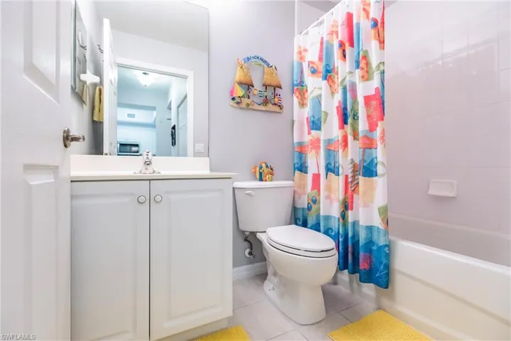 Full bathroom featuring tile flooring, shower / bath combination with curtain, vanity, and toilet