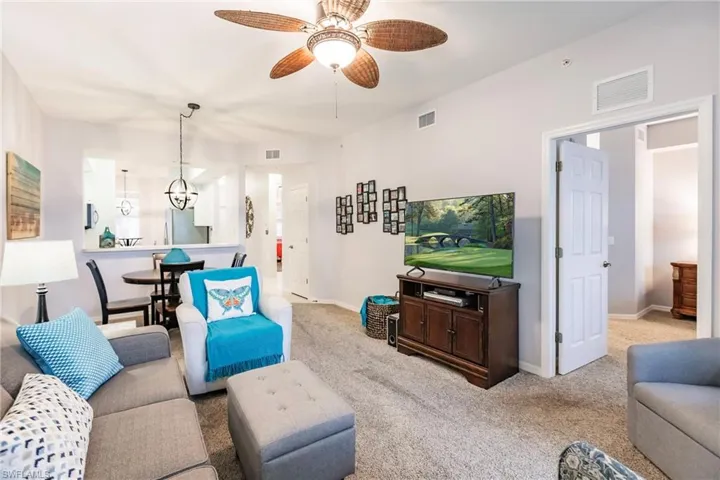 Living room featuring carpet flooring and ceiling fan