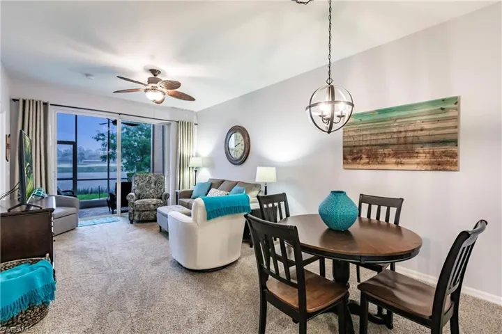 Dining space featuring ceiling fan with notable chandelier and carpet flooring