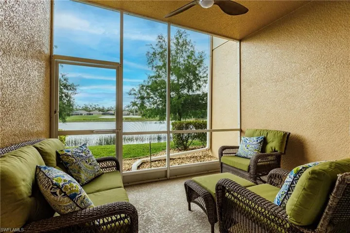 Sunroom featuring ceiling fan and a water view