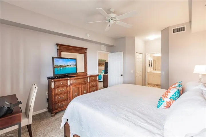Bedroom with carpet, ceiling fan, a closet, and connected bathroom