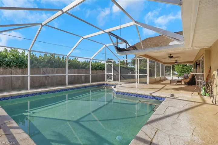 View of pool with a lanai, a sunroom, patio surround, and a fenced backyard