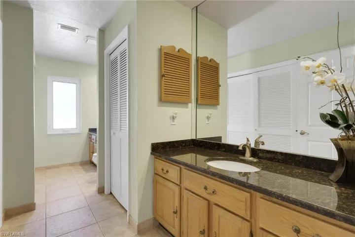 Bathroom with vanity, a closet, and light tile patterned floors