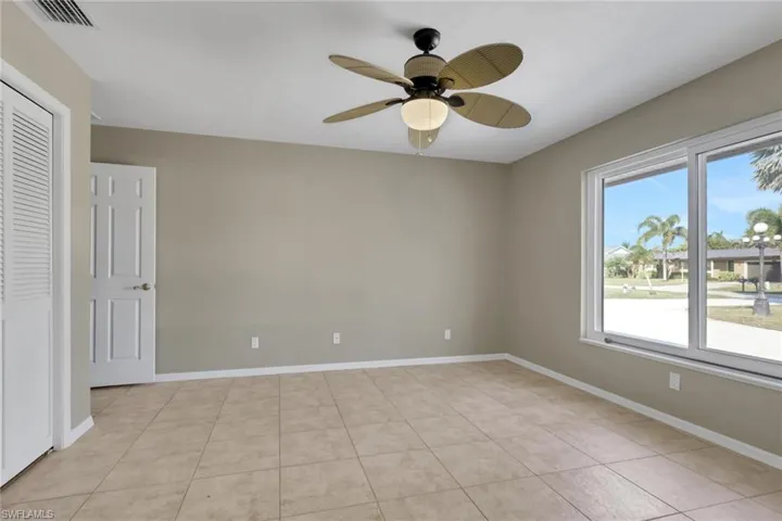 Unfurnished bedroom featuring ceiling fan and light tile patterned floors