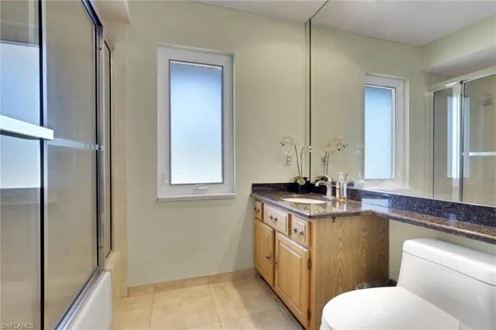 Full bathroom with vanity, combined bath / shower with glass door, and light tile patterned floors