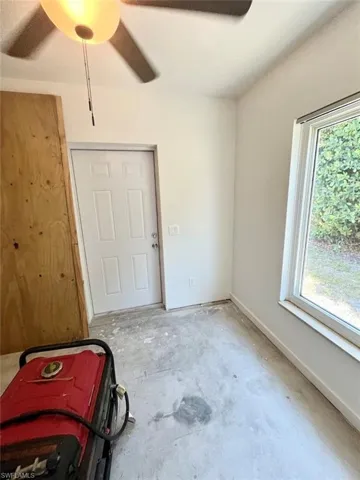 Empty room with unfinished concrete flooring and ceiling fan