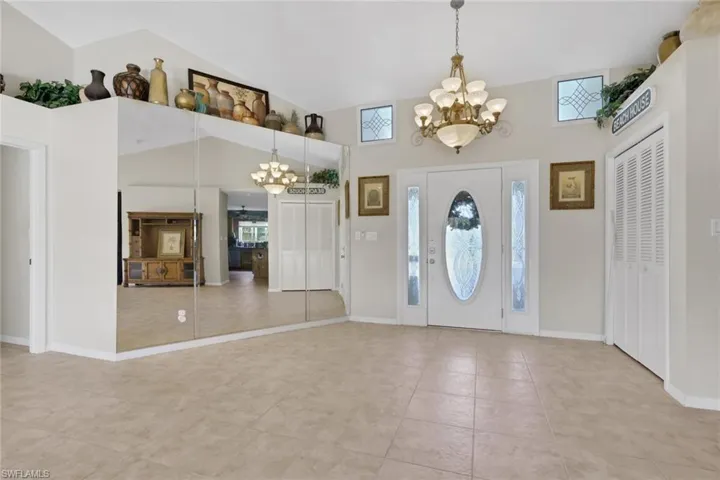 Entrance foyer with suspended lighting, light tile patterned floors, and vaulted ceiling