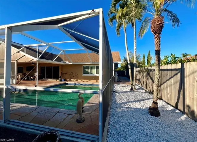 View of pool with a lanai, a sunroom, patio surround, and a fenced backyard