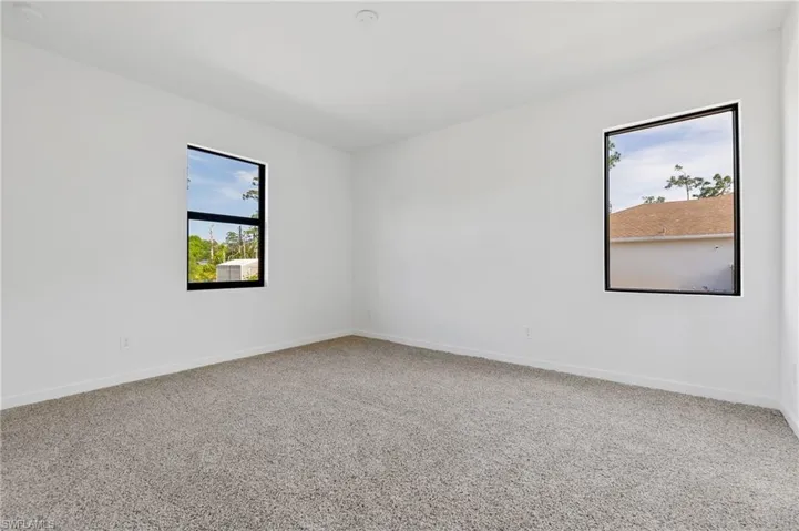 Carpeted empty room with baseboards