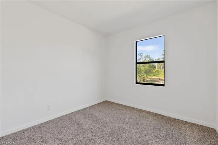Carpeted empty room featuring baseboards