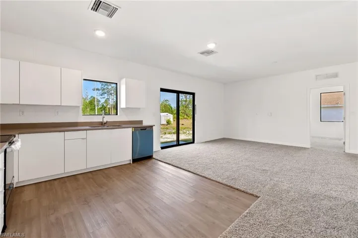 Kitchen featuring dishwasher, visible vents, and a sink