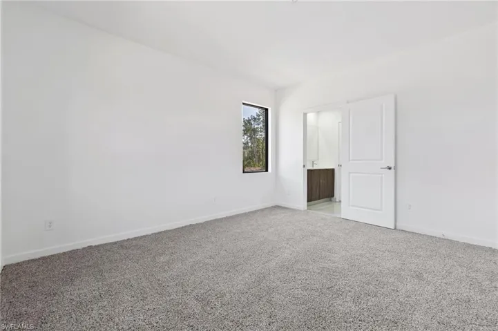 Unfurnished room featuring light colored carpet and baseboards
