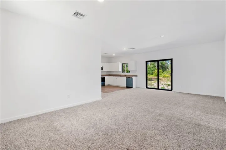 Unfurnished living room featuring baseboards, recessed lighting, visible vents, and light colored carpet