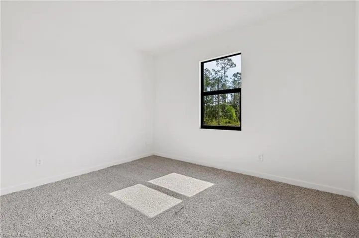 Carpeted empty room featuring baseboards