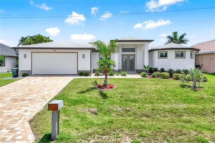 New built house with french doors, stucco siding, an attached garage, paved driveway
