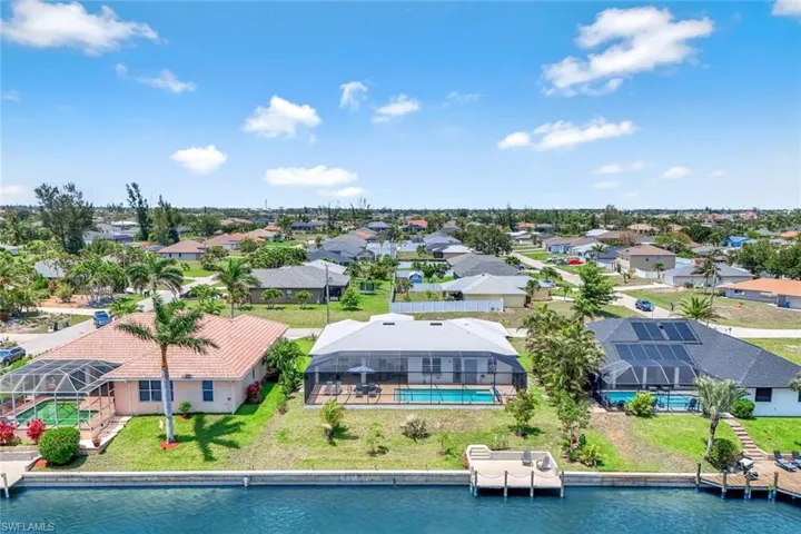 Aerial view of residential area with a pool and a large body of water