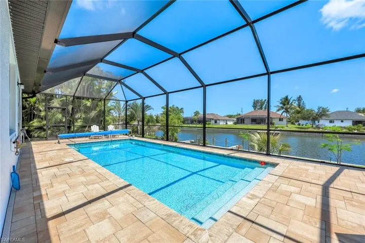 Large pool featuring a water view, a patio area, and a lanai