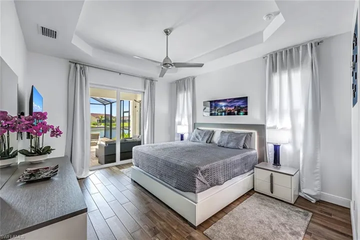 Bedroom with a tray ceiling, access to pool