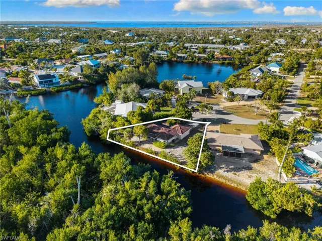 Aerial view of residential area featuring property parcel outlined and a large body of water