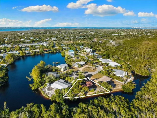 Aerial view of residential area featuring a nearby body of water and property boundaries highlighted