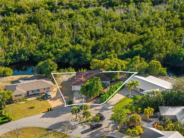 Aerial view of property and surrounding area featuring a large body of water and property boundaries highlighted