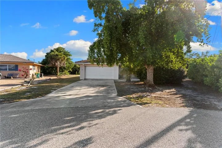 View of front of home featuring concrete driveway, stucco siding, and a garage
