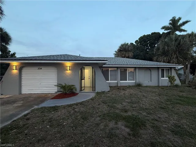 View of front of property with a garage, stucco siding, and driveway