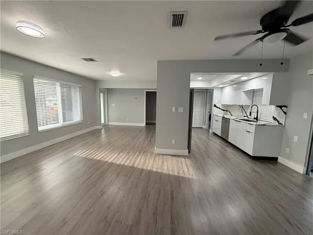 Unfurnished living room featuring a ceiling fan and wood finished floors