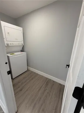 Laundry area featuring estacked washer and dryer and wood finished floors