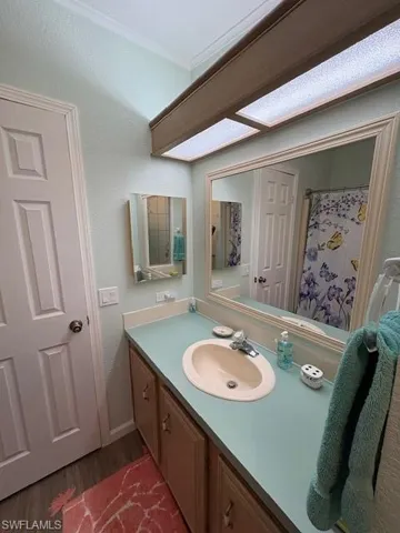 Full bath with wood finished floors and vanity