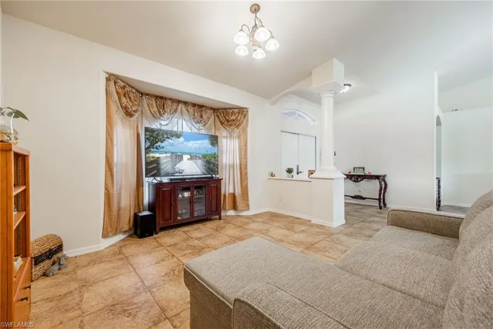 Living room 2 featuring vaulted ceiling, baseboards, arched walkways, and ornate columns
