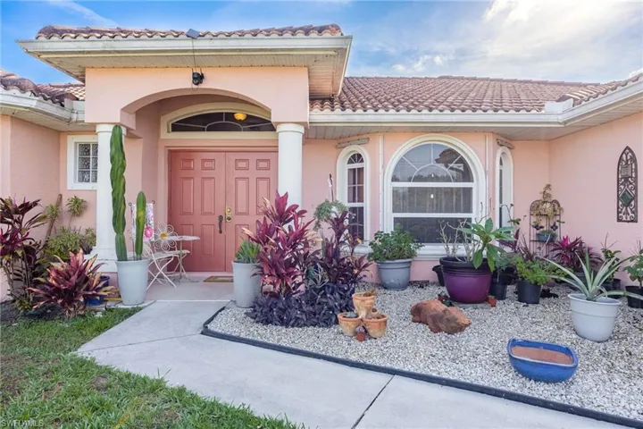 View of exterior entry featuring a tiled roof and stucco siding