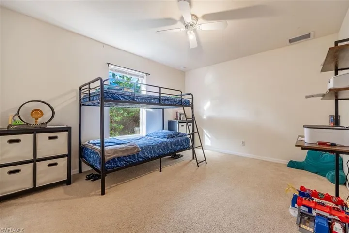 Bedroom featuring baseboards, ceiling fan, visible vents, and light colored carpet