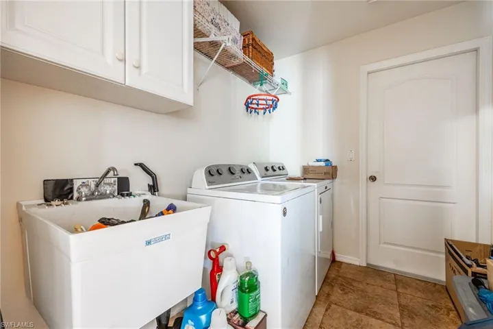 Laundry room with cabinet space, a sink, and washing machine and clothes dryer