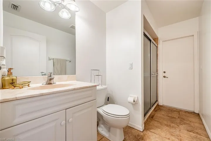 Full bathroom featuring visible vents, toilet, a stall shower, vanity, and baseboards