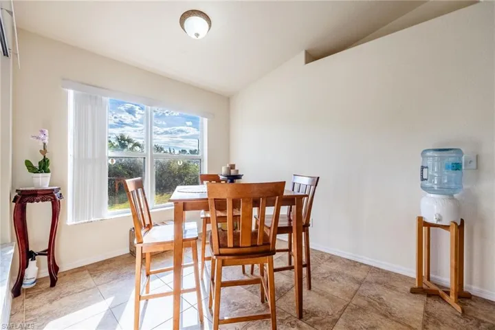 Dining room featuring lofted ceiling and baseboards