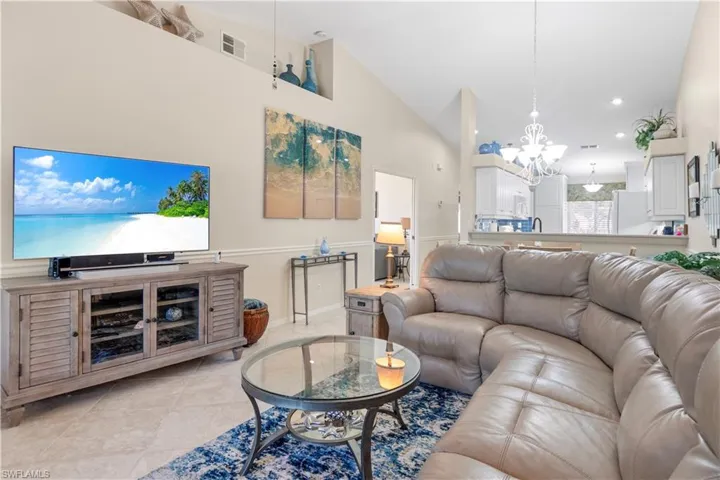 Tiled living room featuring high vaulted ceilings