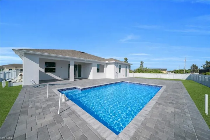 View of swimming pool with patio surround and a fenced backyard