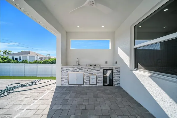 View of patio / terrace featuring a ceiling fan, an outdoor kitchen, and beverage cooler