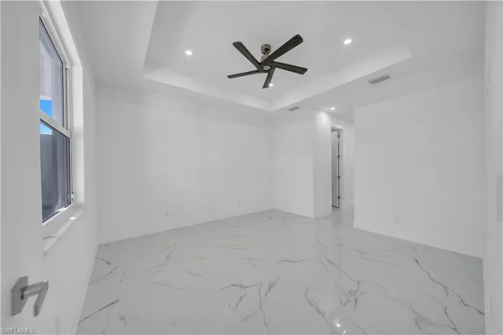Unfurnished room with a ceiling fan, recessed lighting, and a raised ceiling