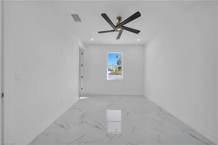 Empty room with light marble finish flooring, ceiling fan, and recessed lighting